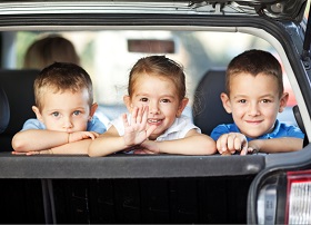 3 kids in the back of a car